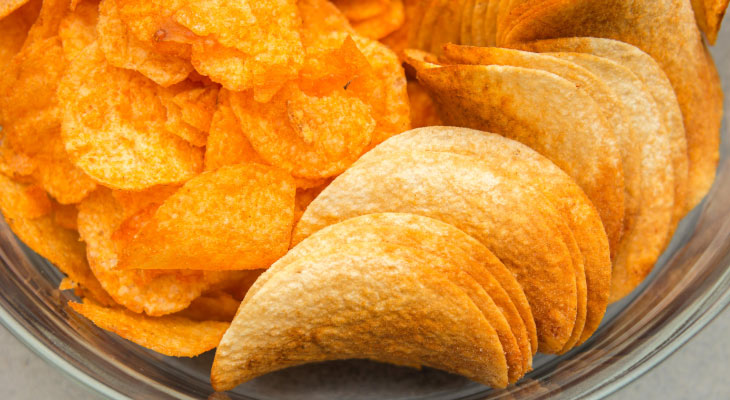 Aerial view of orange Pringles chips that can damage teeth with sugar content