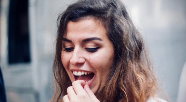 girl holding her lower tooth with a dental emergency