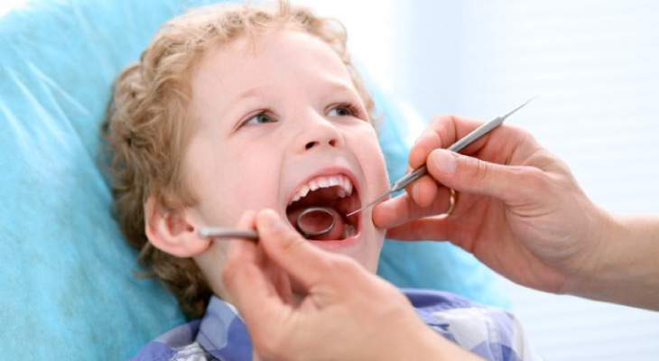 young boy in the dentist's chair getting a checkup