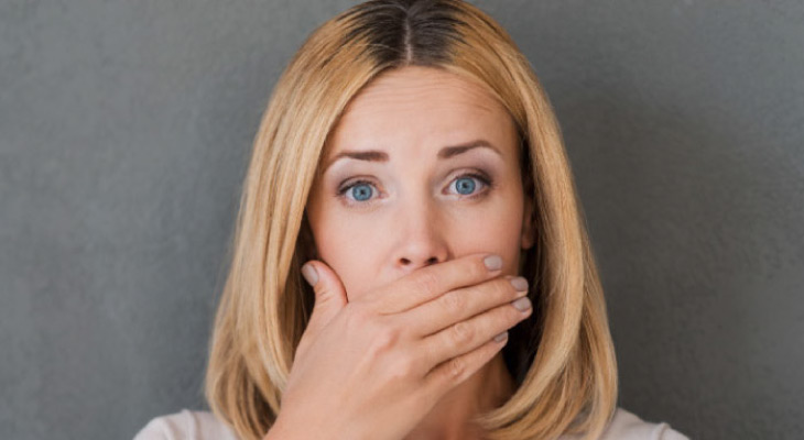 woman covering her mouth to hide periodontal disease