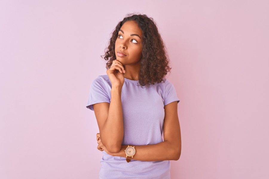 Brunette woman in a lavender shirt wonders if her teeth need a deep cleaning to treat gum disease