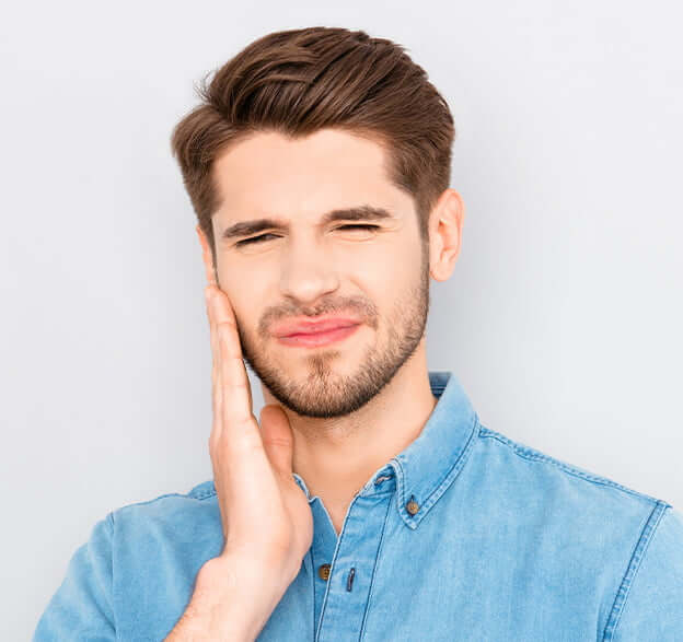 man holding his jaw in pain