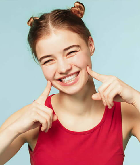 girl smiling pointing at cheeks