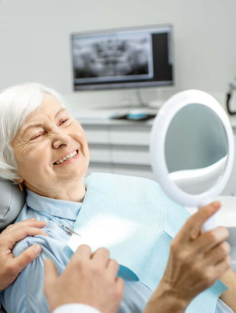 woman with a mirror looking at smile