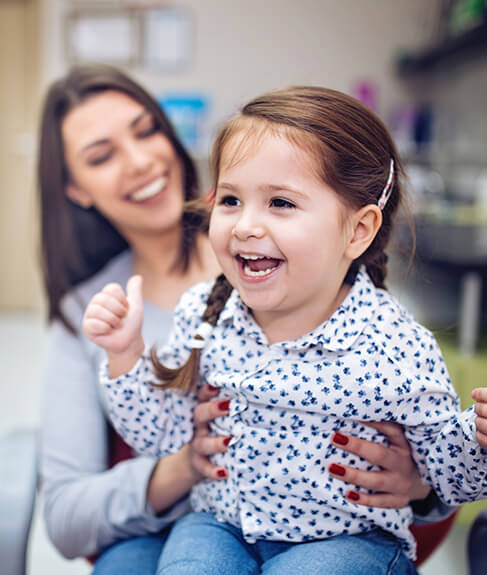 happy young girl being held by her mother