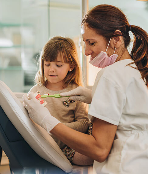 dentist and child cleaning teeth